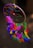 A vibrant dream catcher with blue and purple feathers hanging against a soft background.