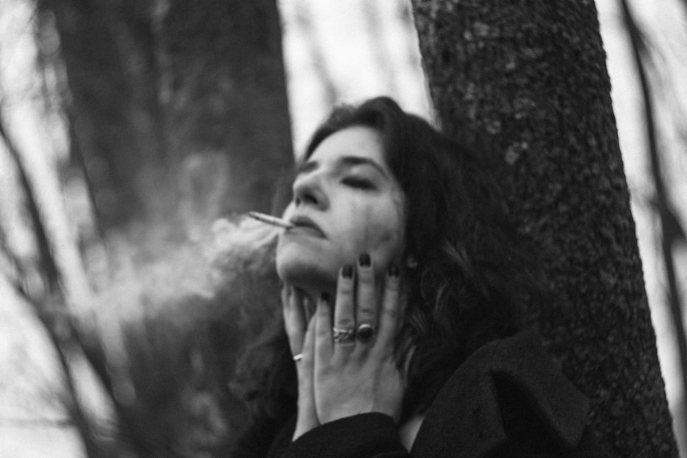 grayscale photo of woman smoking cigarette