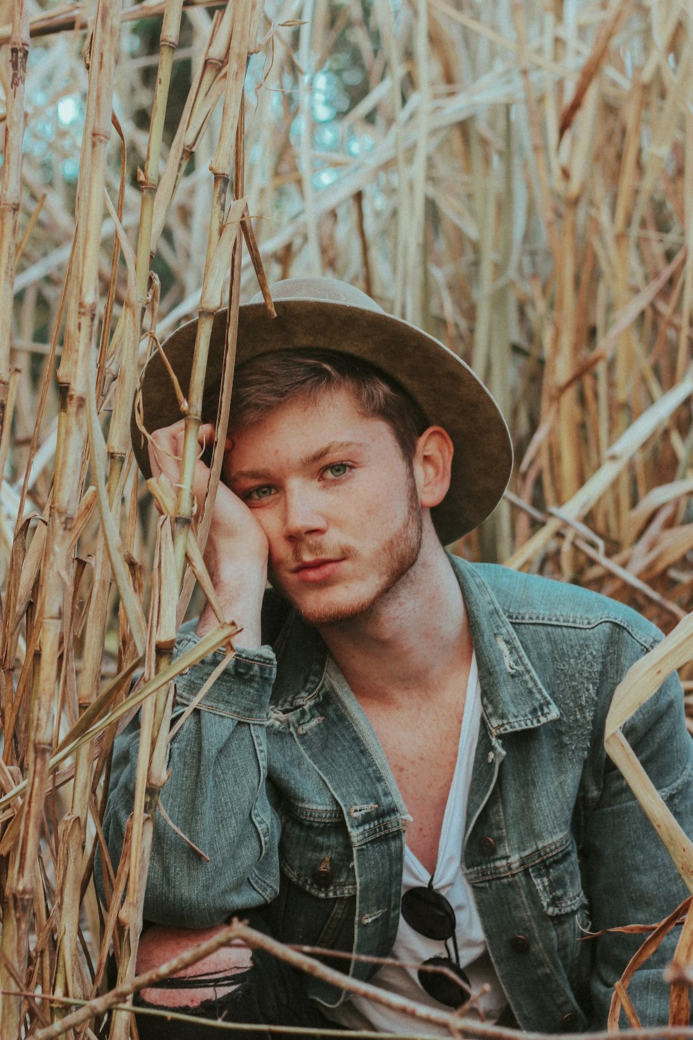 man in blue denim jacket wearing brown hat