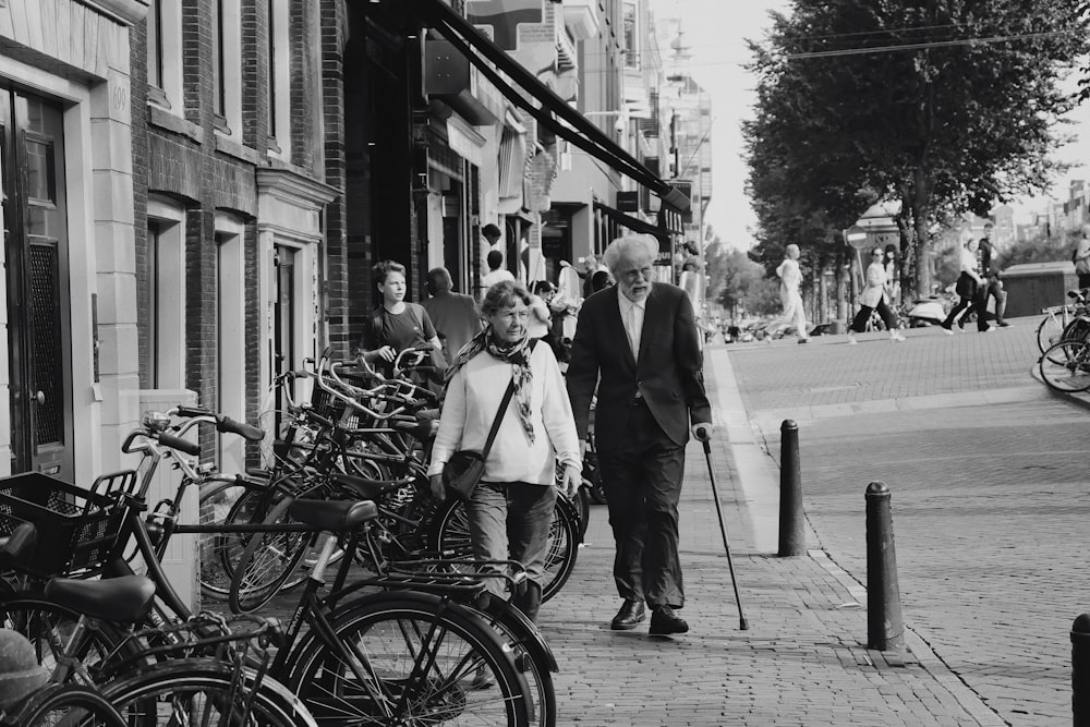 man and woman riding on bicycle in grayscale photography