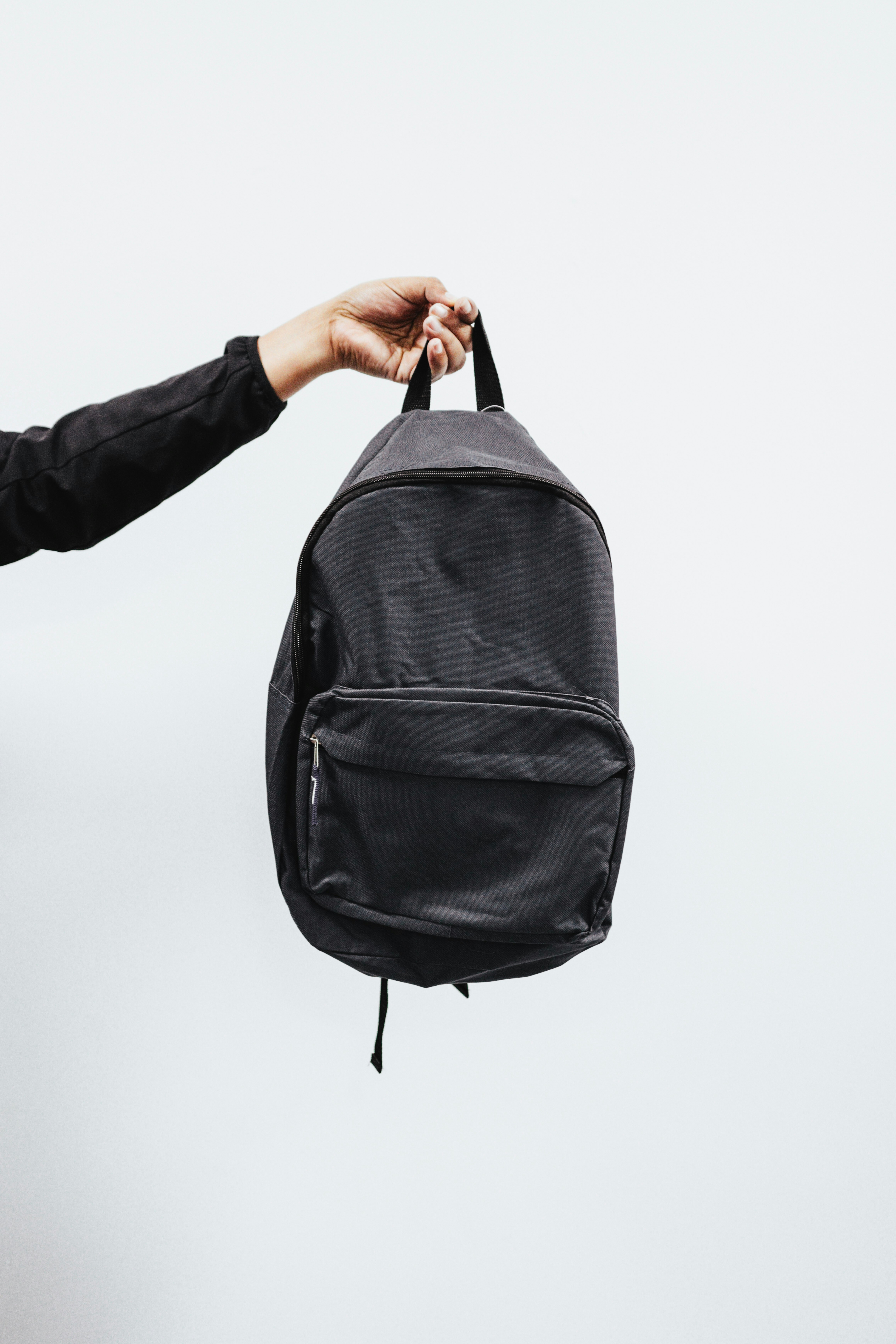 A neatly organized daypack with a microfiber towel, deck of cards, and hand sanitizer peeking out