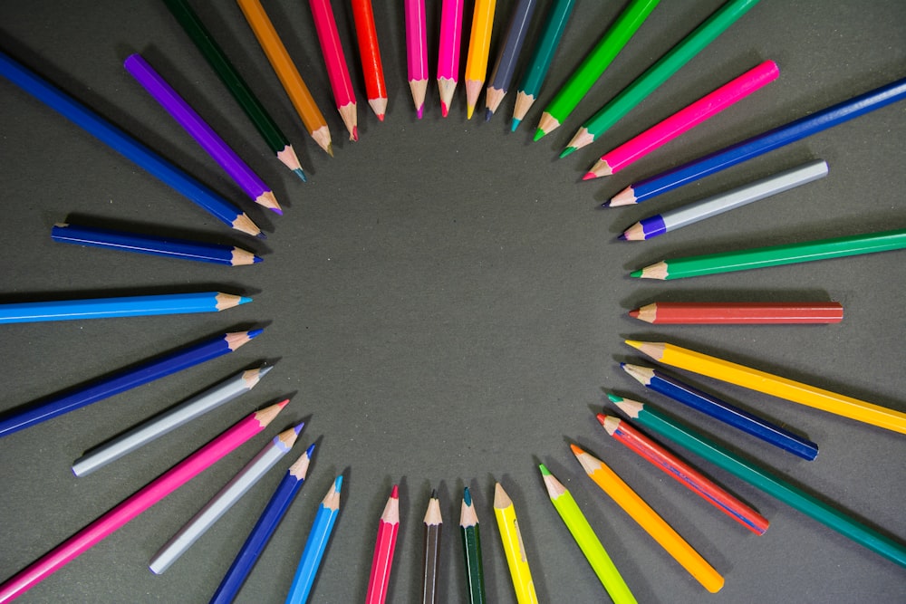 lápis multicoloridos na superfície preta