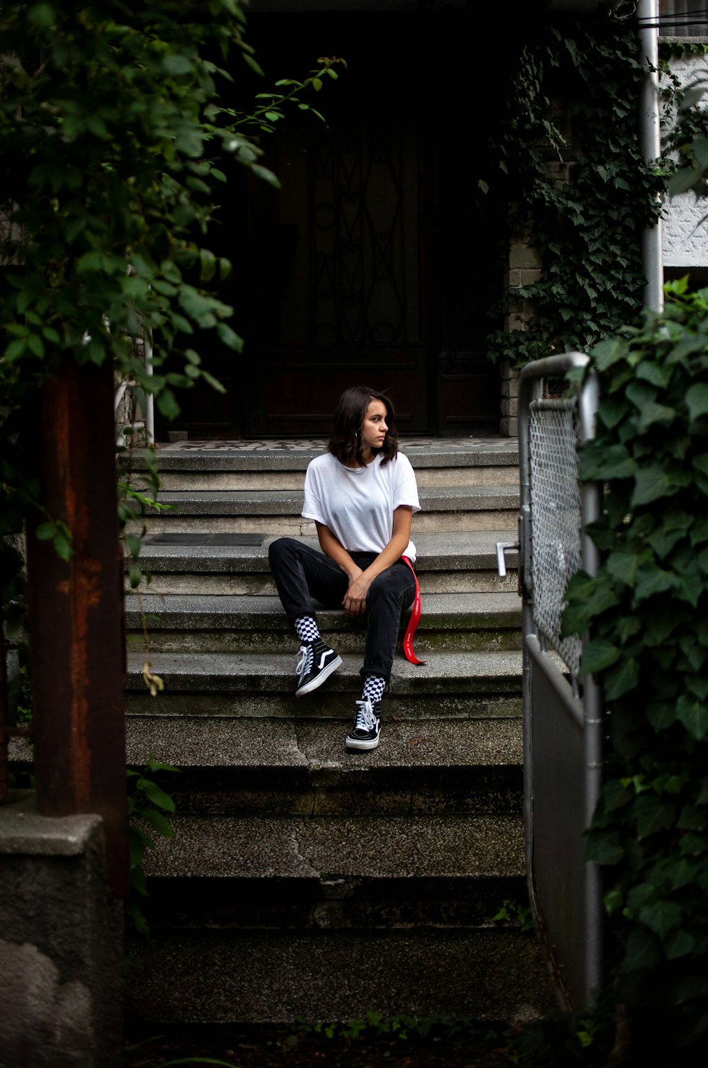 man in white t-shirt sitting on gray concrete stairs