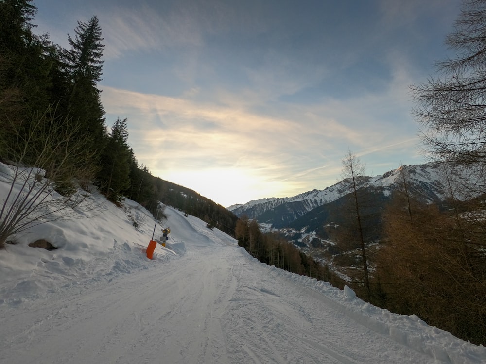 person in orange jacket and black pants on snow covered ground during daytime