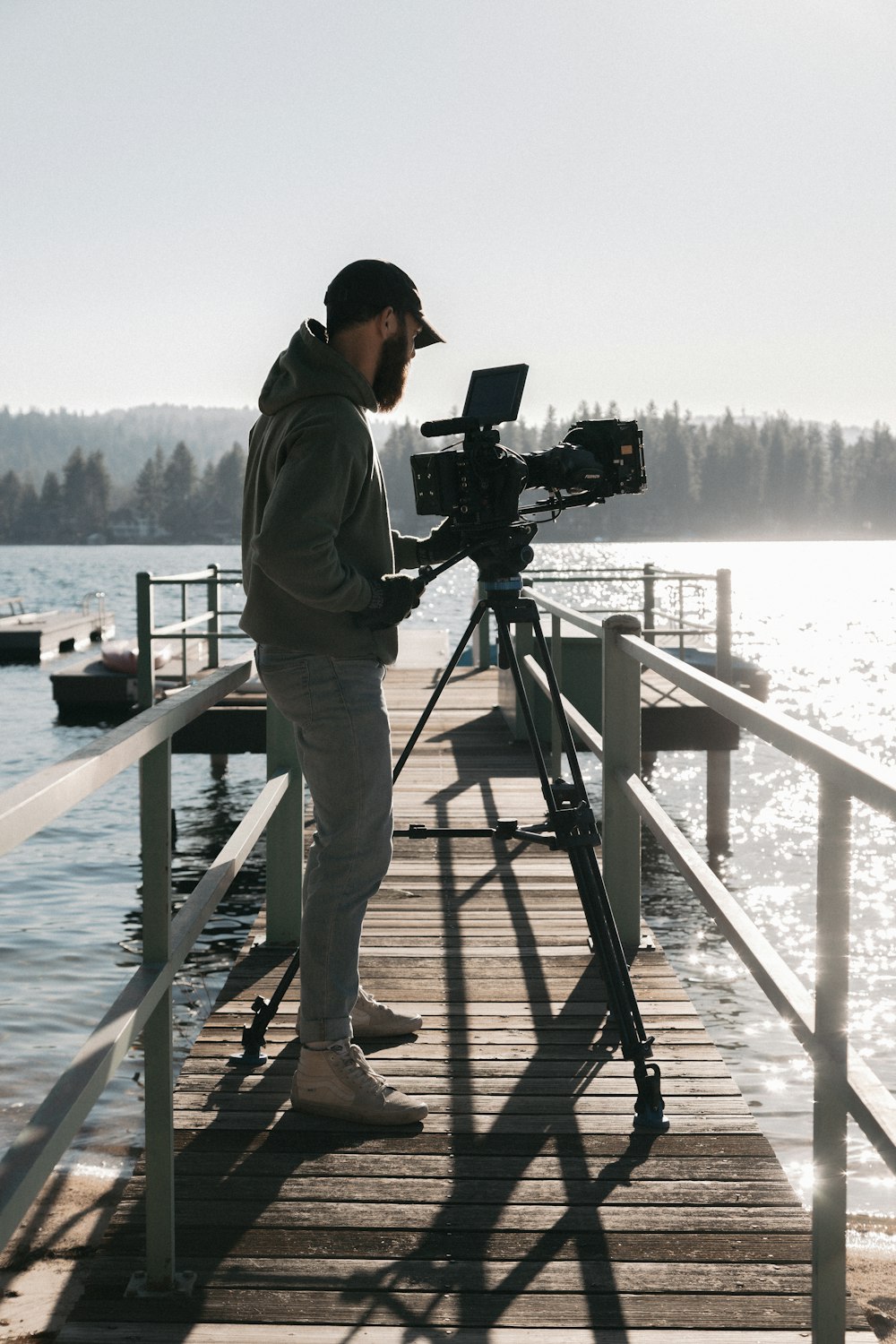 man in brown jacket and brown pants standing on dock holding camera