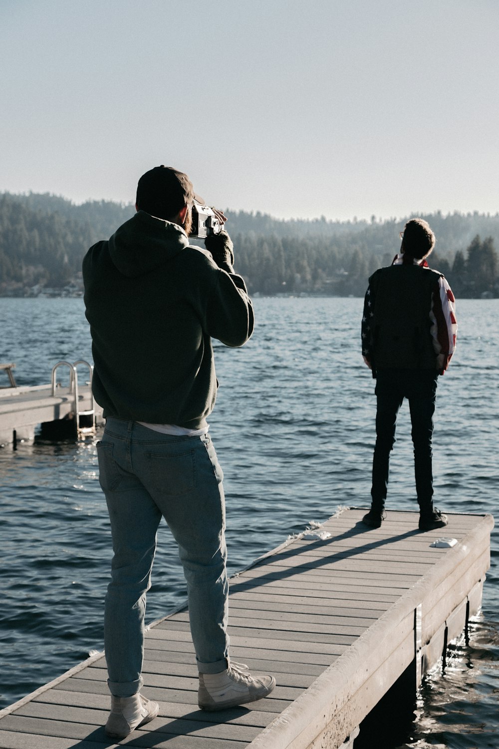 man and woman standing on wooden dock during daytime