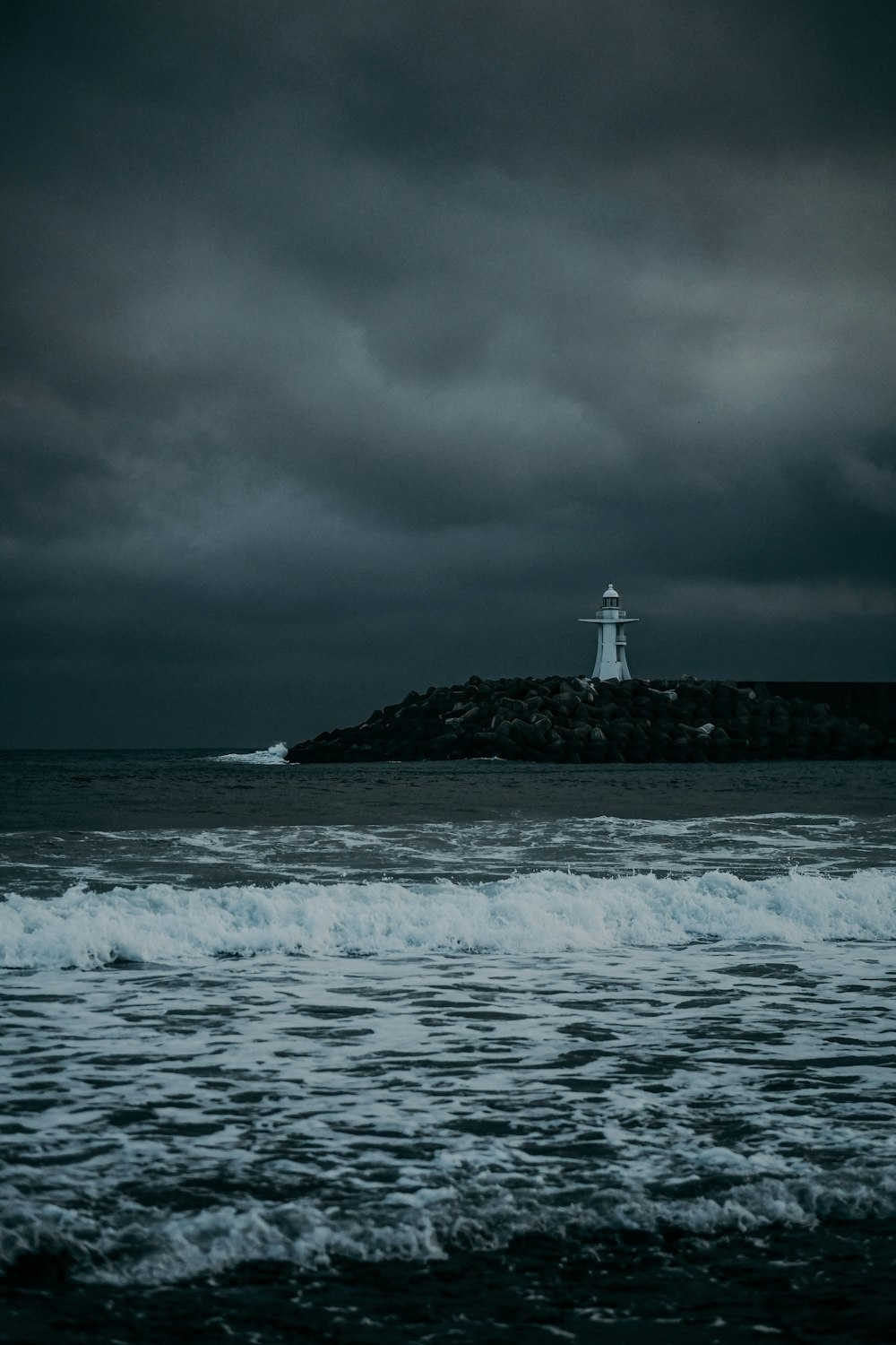 a lighthouse on a small island in the middle of the ocean