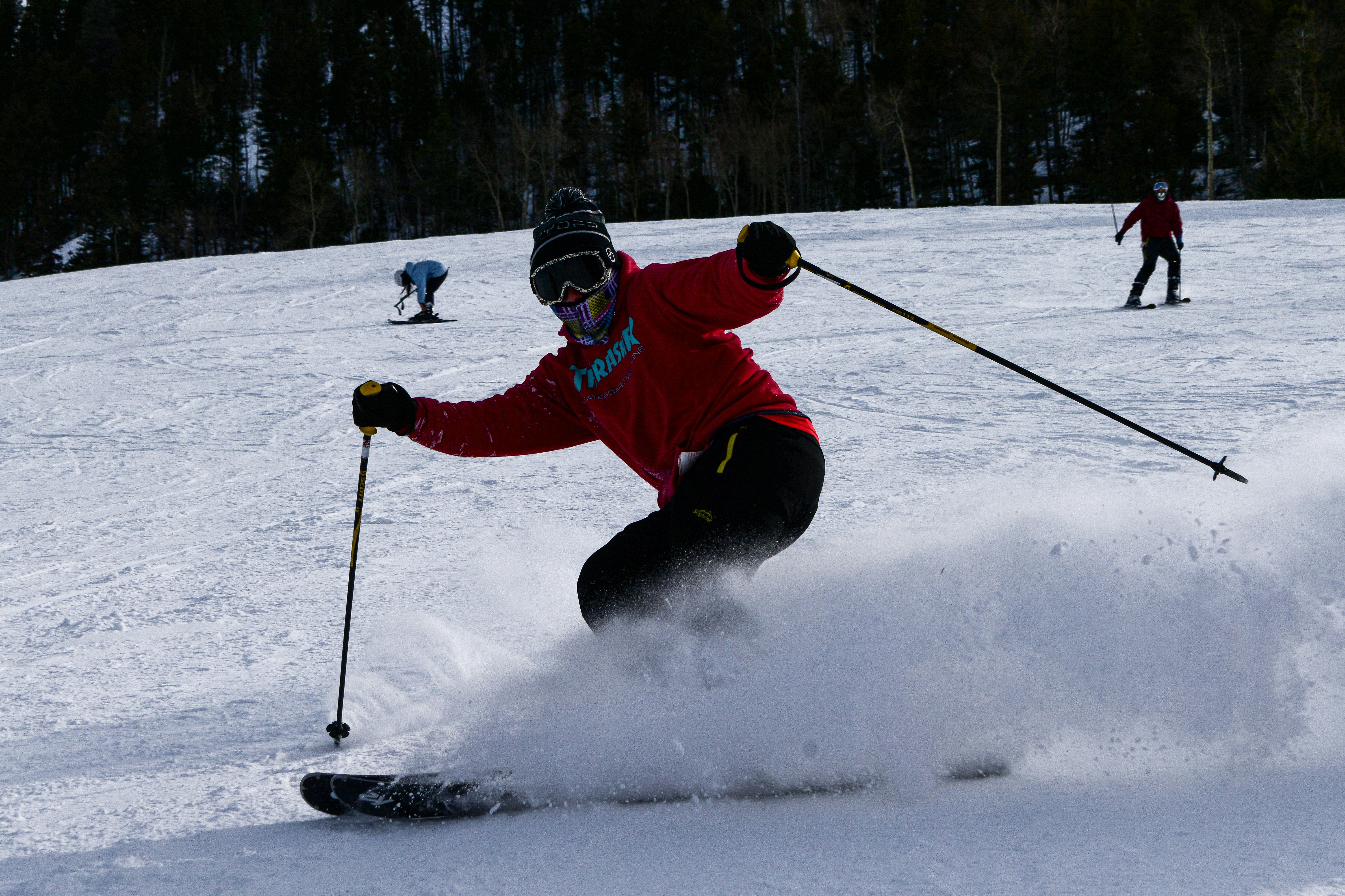 person in red jacket and black pants riding on ski blades on snow covered ground during