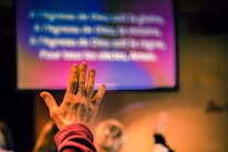 Close-up of hands raised in worship during a live online service.