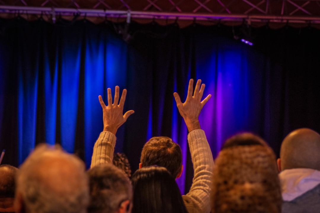 people raising their hands on the stage