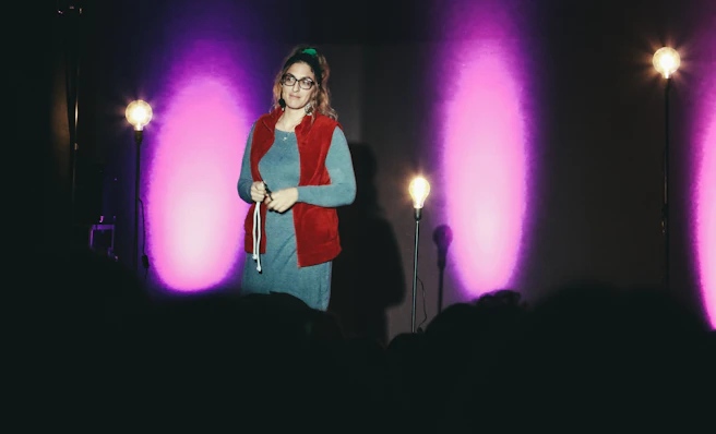 woman in red and white long sleeve shirt standing on stage