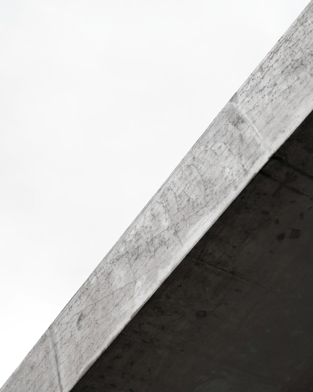 poteau en béton gris sous le ciel blanc pendant la journée