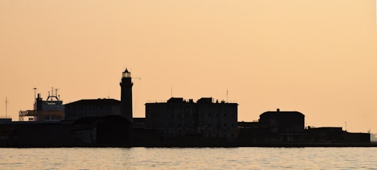 gray concrete building near body of water during daytime in Trieste Italy