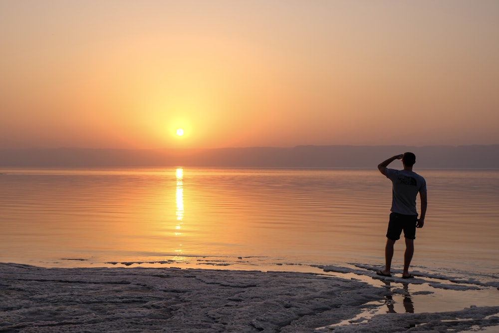 woman in white dress standing on beach during sunset