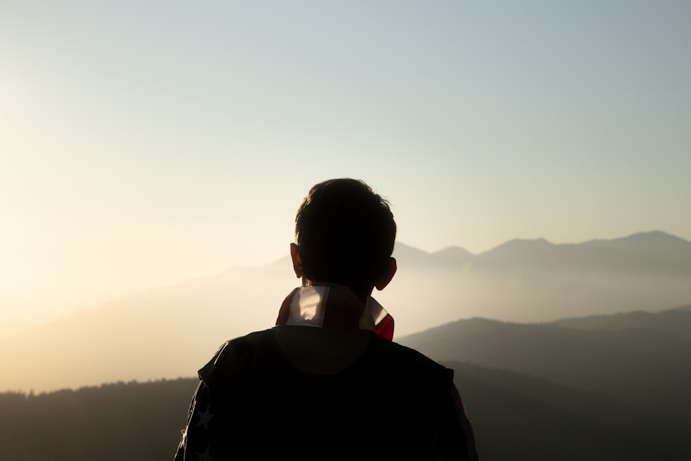 man in black jacket wearing black headphones during sunset