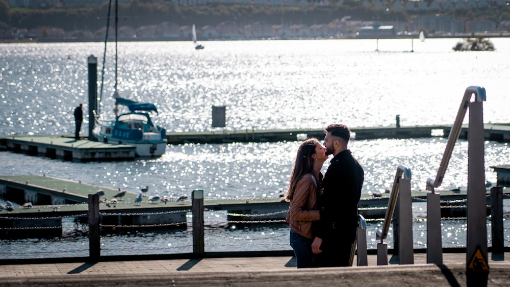 couple standing on wooden dock during daytime