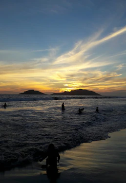 A vibrant photo of travelers enjoying a scenic sunset at Labuan Bajo beach.