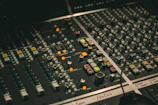 Professional audio mixing console with green and gold lighting accents