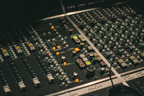 Sound mixing board with colorful lights and dials in a dimly lit room