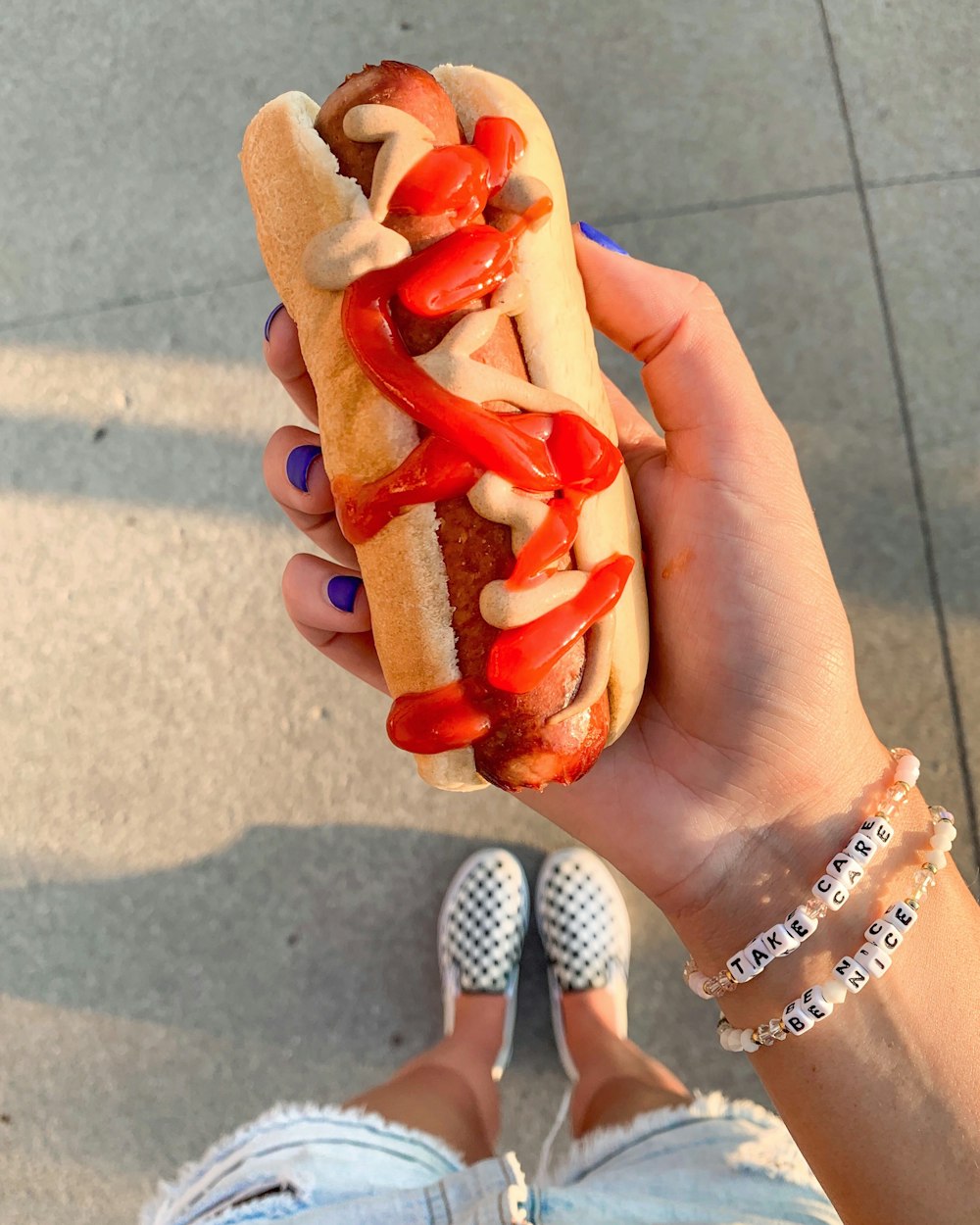 a person holding a hot dog in their hand