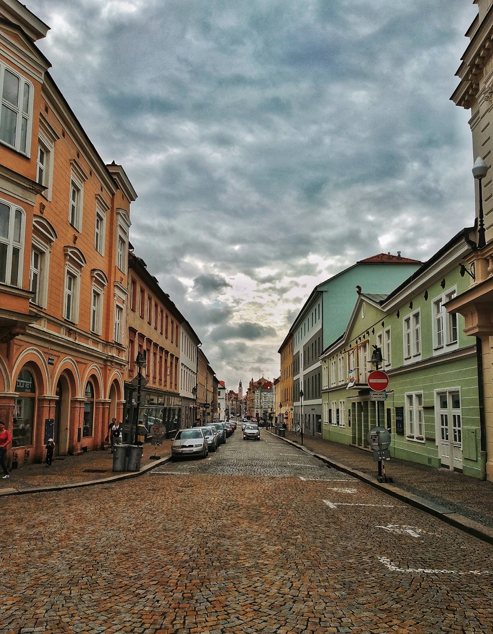 cars parked beside road near buildings during daytime