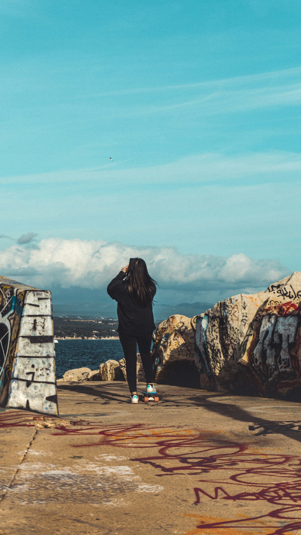 woman in black jacket standing on brown sand during daytime