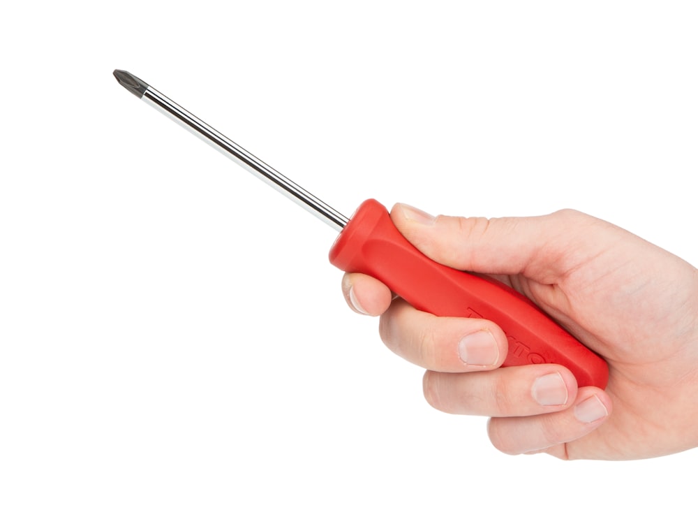 person holding red and silver screw driver