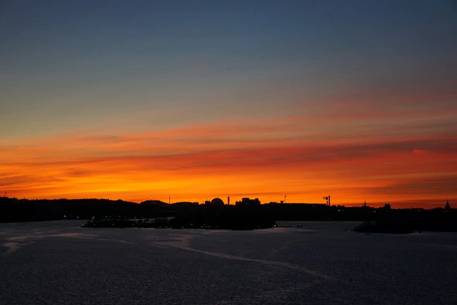 A vibrant sunset over Buffalo's skyline with Lake Erie in the foreground.