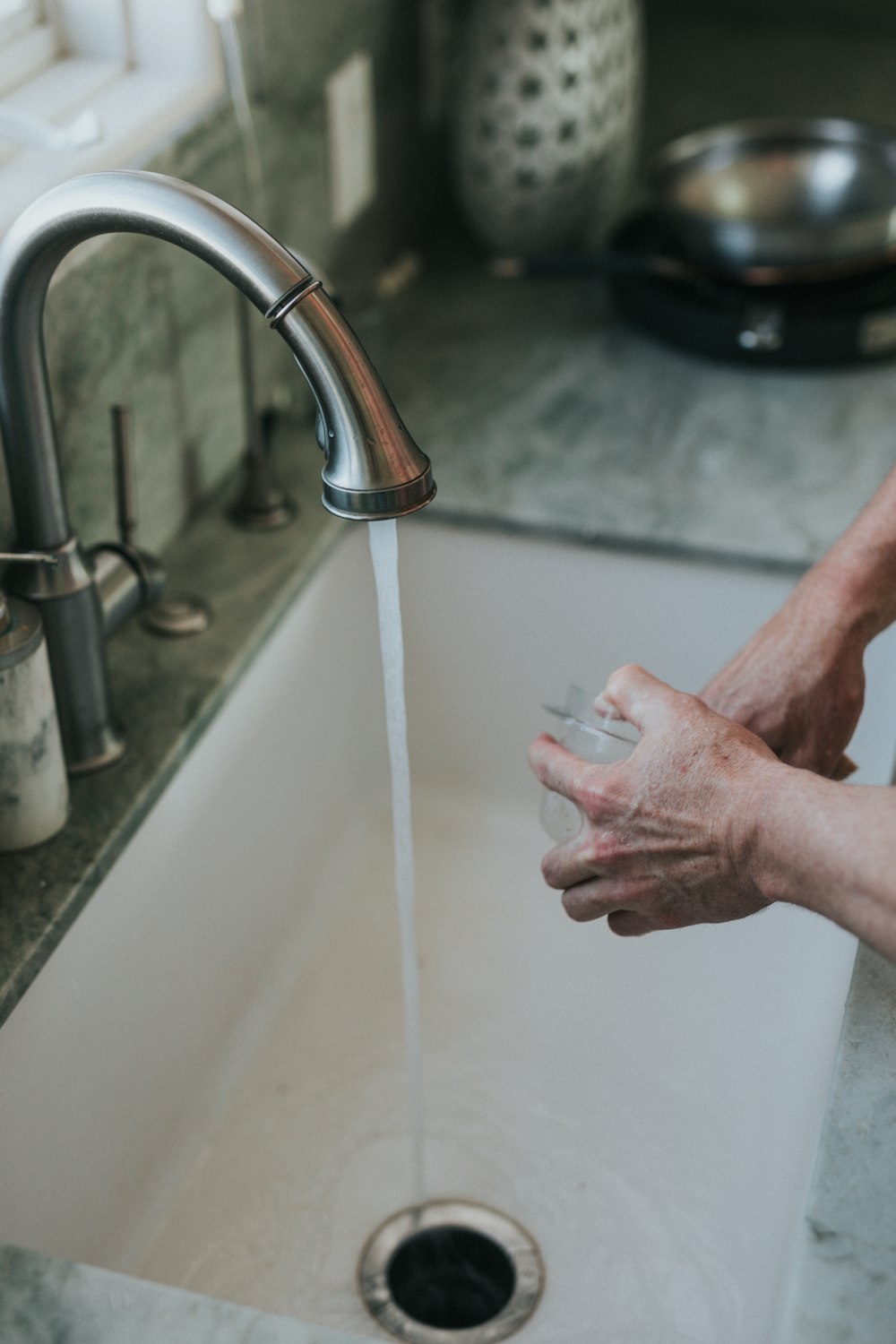 person washing hand on faucet