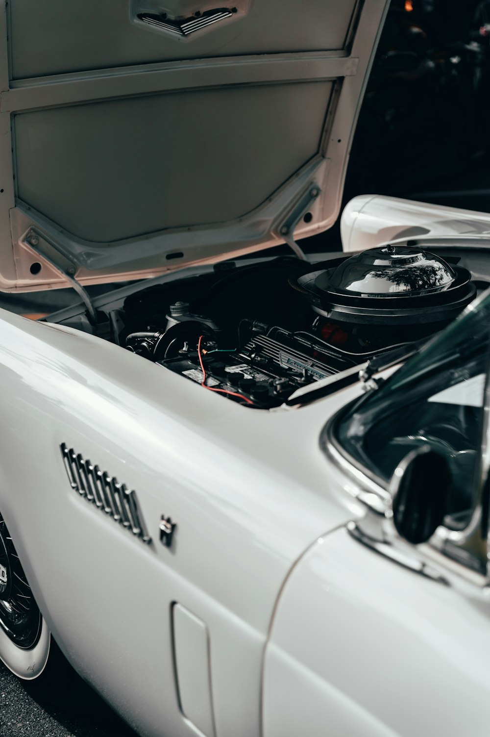 a white car with its hood open and its hood up