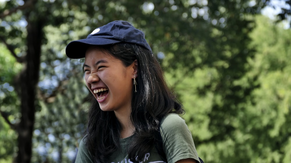 woman in black hat and gray long sleeve shirt smiling