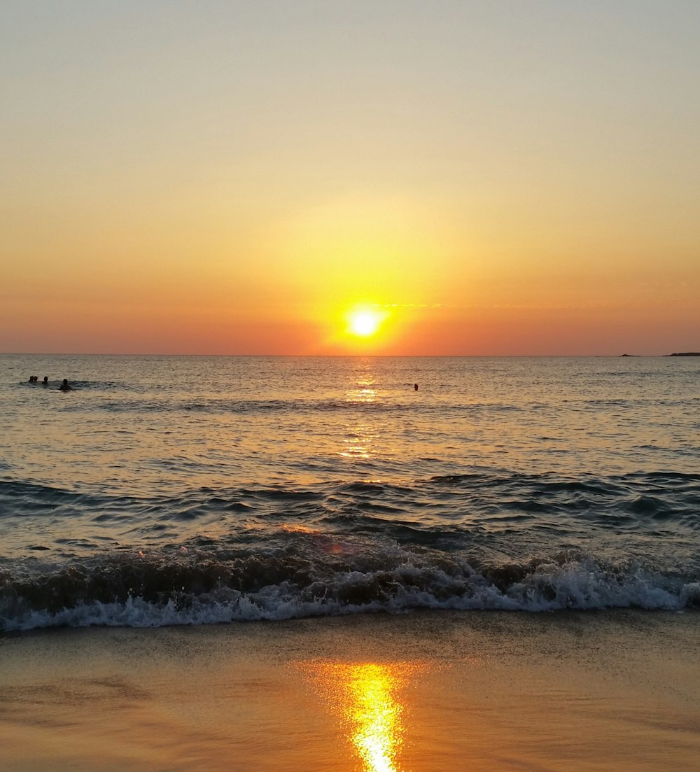 sea waves crashing on shore during sunset