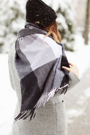 Model wearing a classic solid color scarf paired with a winter coat outdoors.