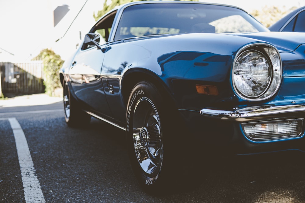 blue classic car in a parking lot