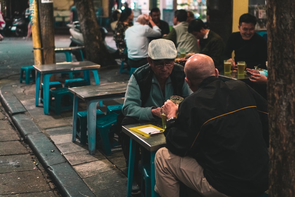 homme en veste verte assis sur un banc bleu