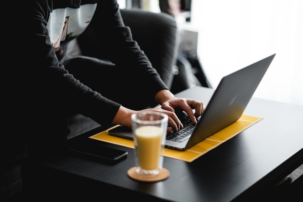 person in black jacket using macbook pro