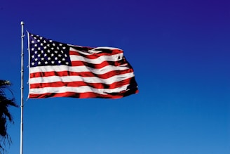 us a flag on pole under blue sky during daytime