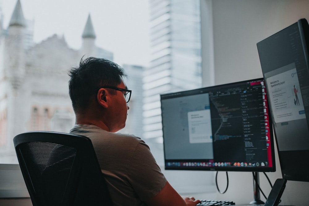 man in brown shirt wearing black framed sunglasses sitting on black office rolling chair