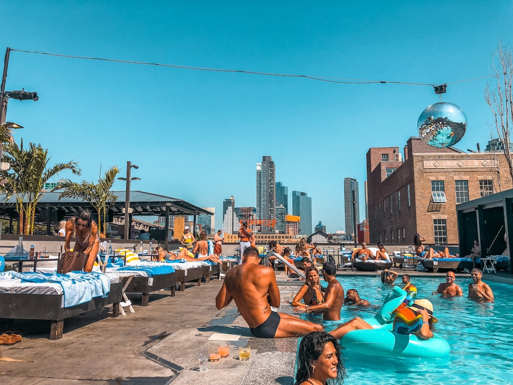 people on blue and white beach lounge chairs near body of water during daytime