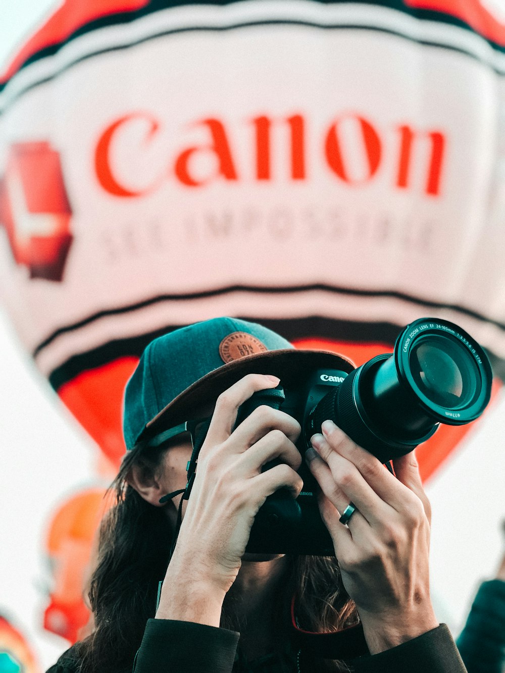 woman in black and brown knit cap holding black dslr camera