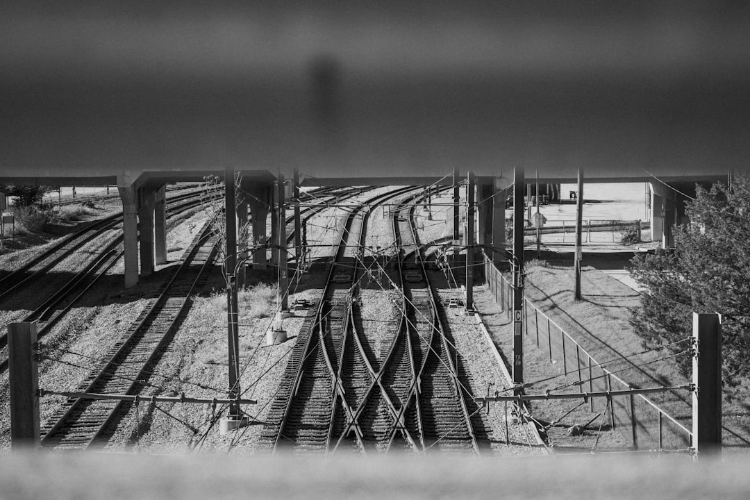 grayscale photo of a train rail,