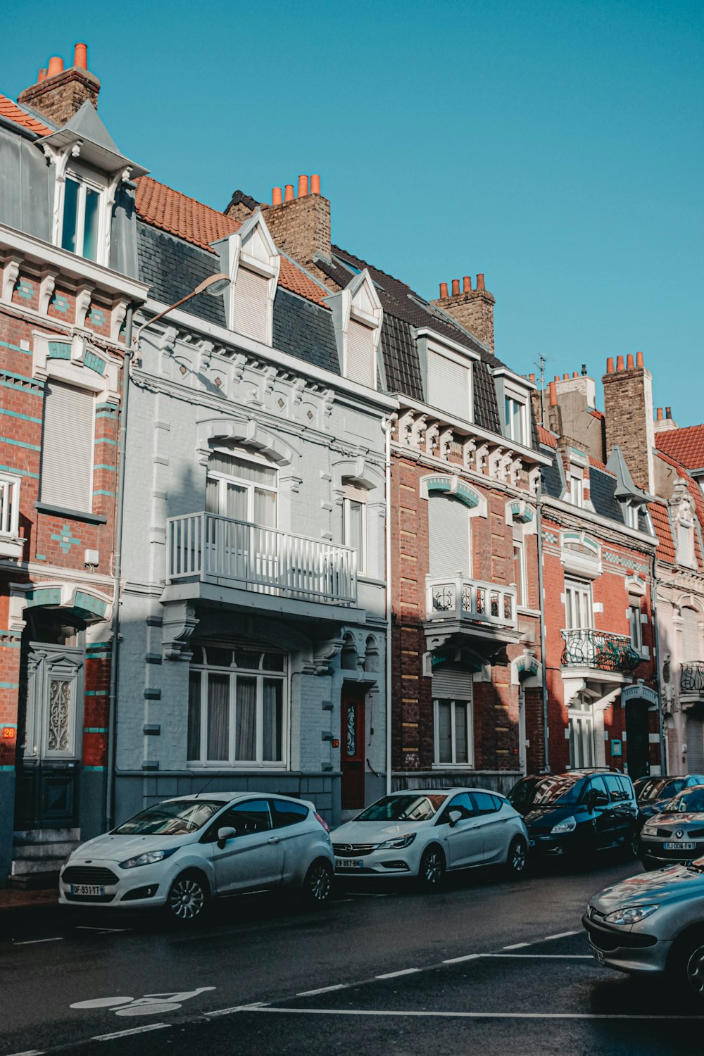 cars parked in front of white concrete building during daytime