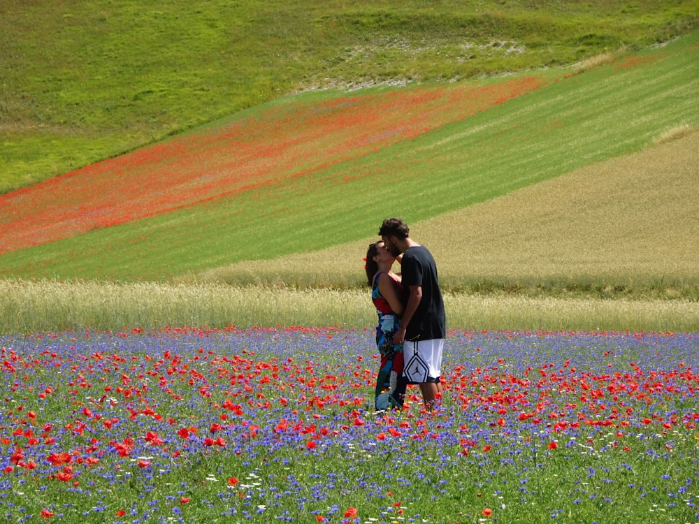 um homem e uma mulher se beijando em um campo de flores