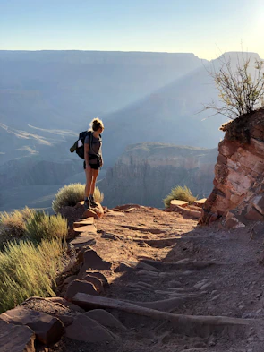 A hiker wearing a leather jacket with a Sedona vortex medallion glowing softly in the sunlight.