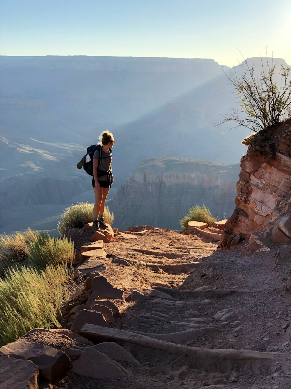 woman in black shirt standing on brown rock formation during daytime