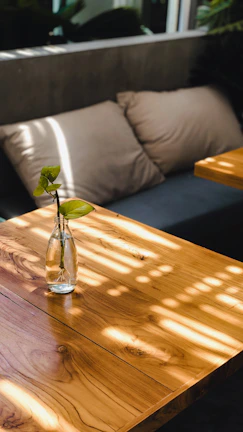 A polished resin table reflecting soft natural light near a cozy corner.