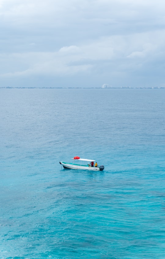 white and blue boat on sea during daytime in Isla Mujeres Mexico