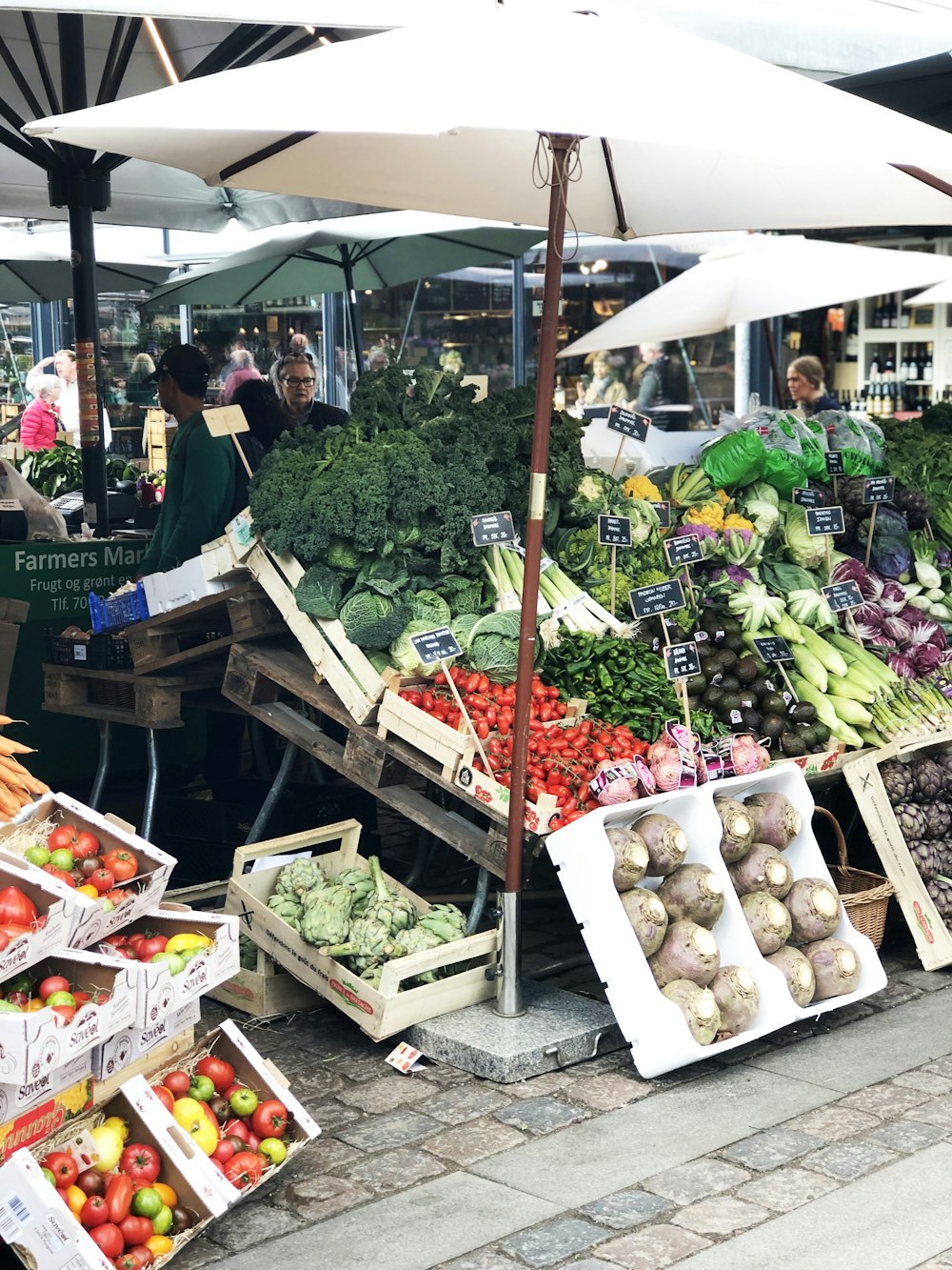 people standing in front of vegetable stand during daytime