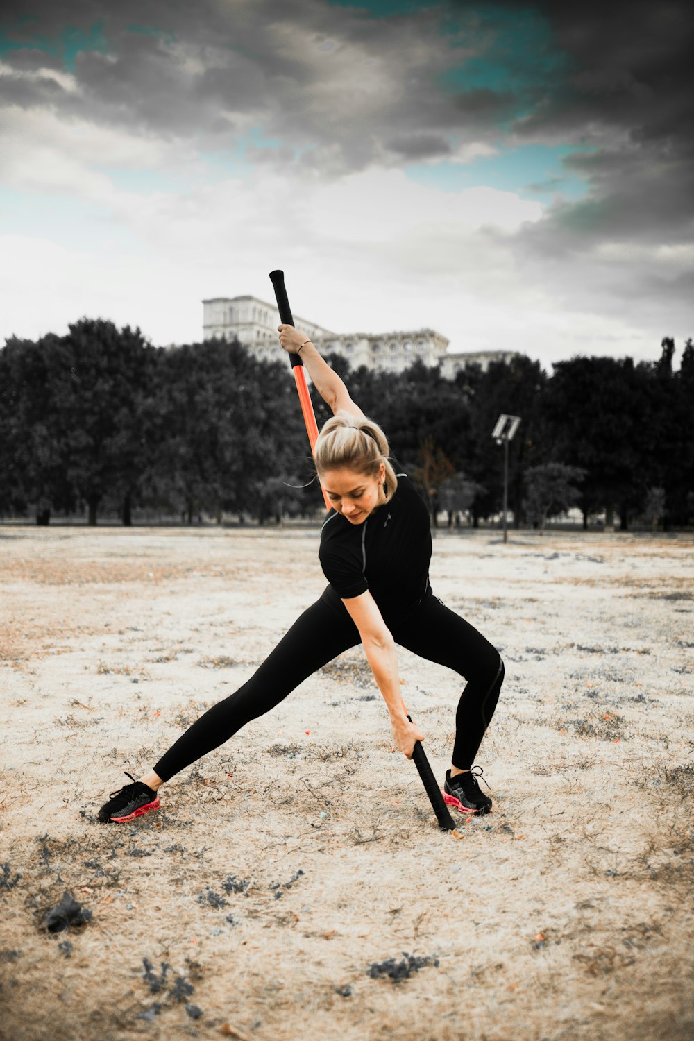 woman in black leggings and black tank top holding baseball bat