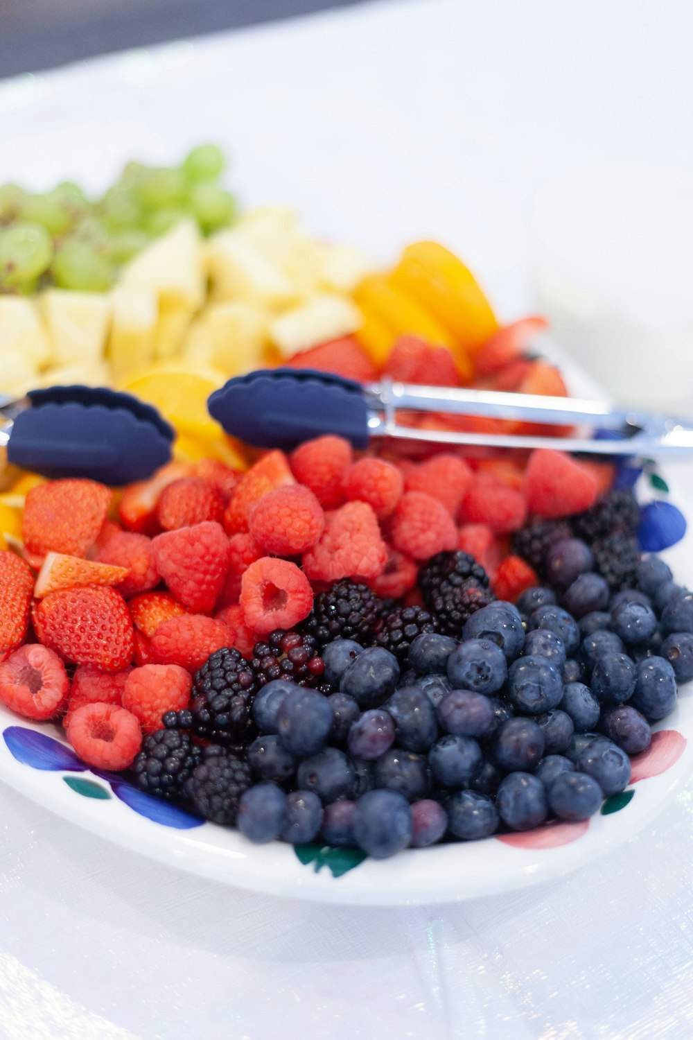 blue berries and sliced fruits on white ceramic bowl